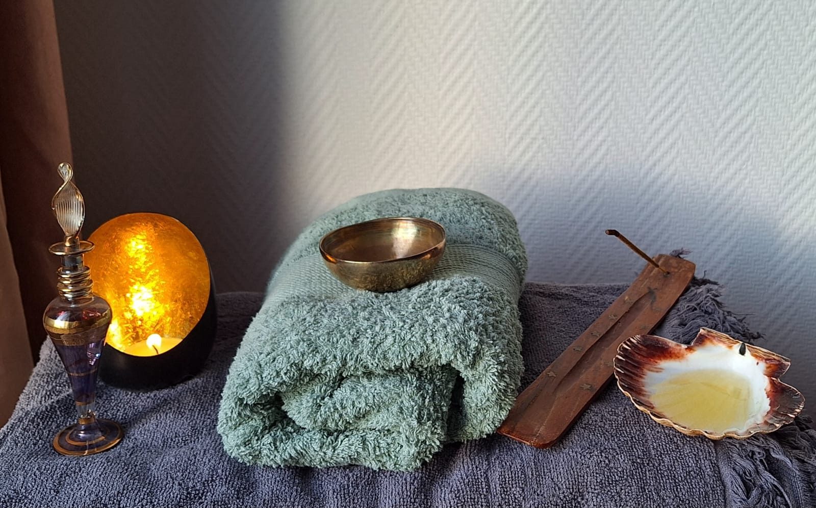 Serviettes, bol et bougie pour un massage bien-être à Nantes